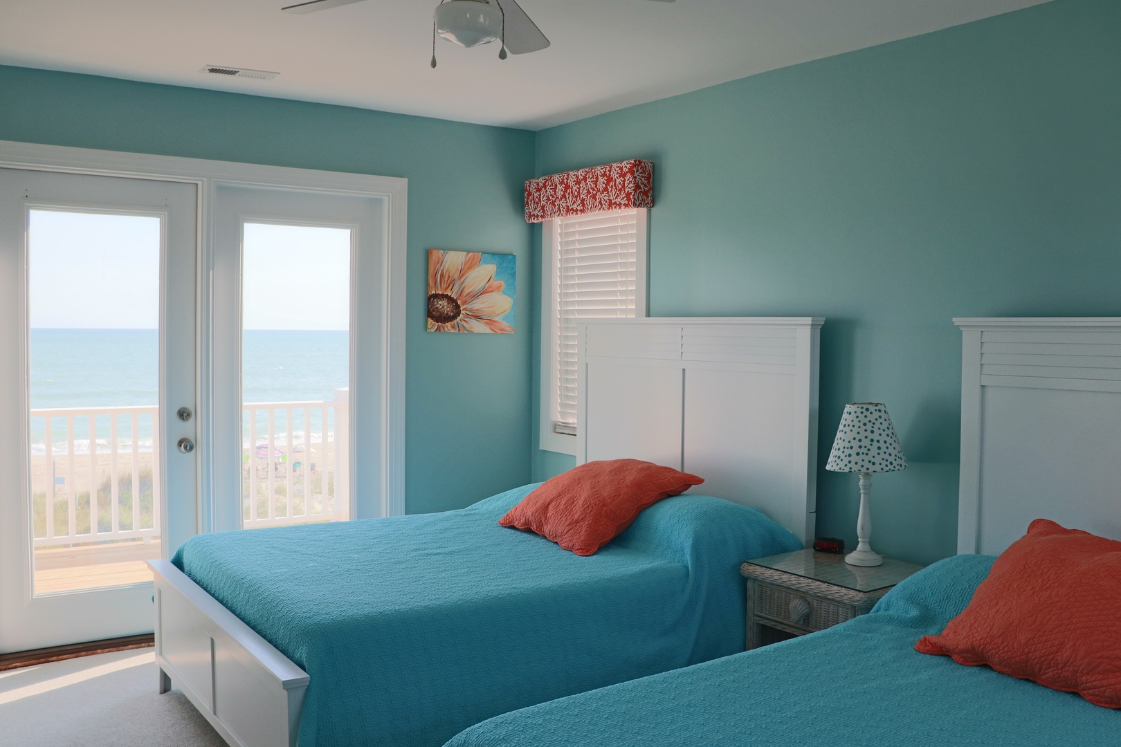 Wake up to ocean breezes in this cheerful twin bedroom, where turquoise walls and coral accents create your perfect coastal retreat.