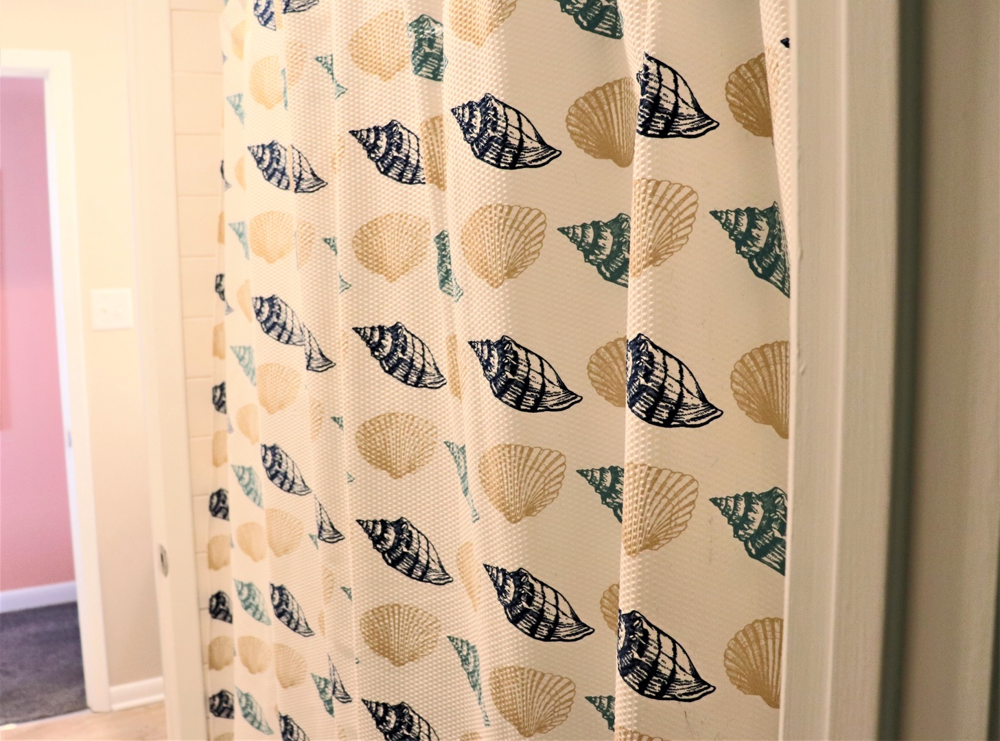 Charming seashell-patterned curtain adds coastal flair to your bathroom, creating a beachy retreat feeling.
