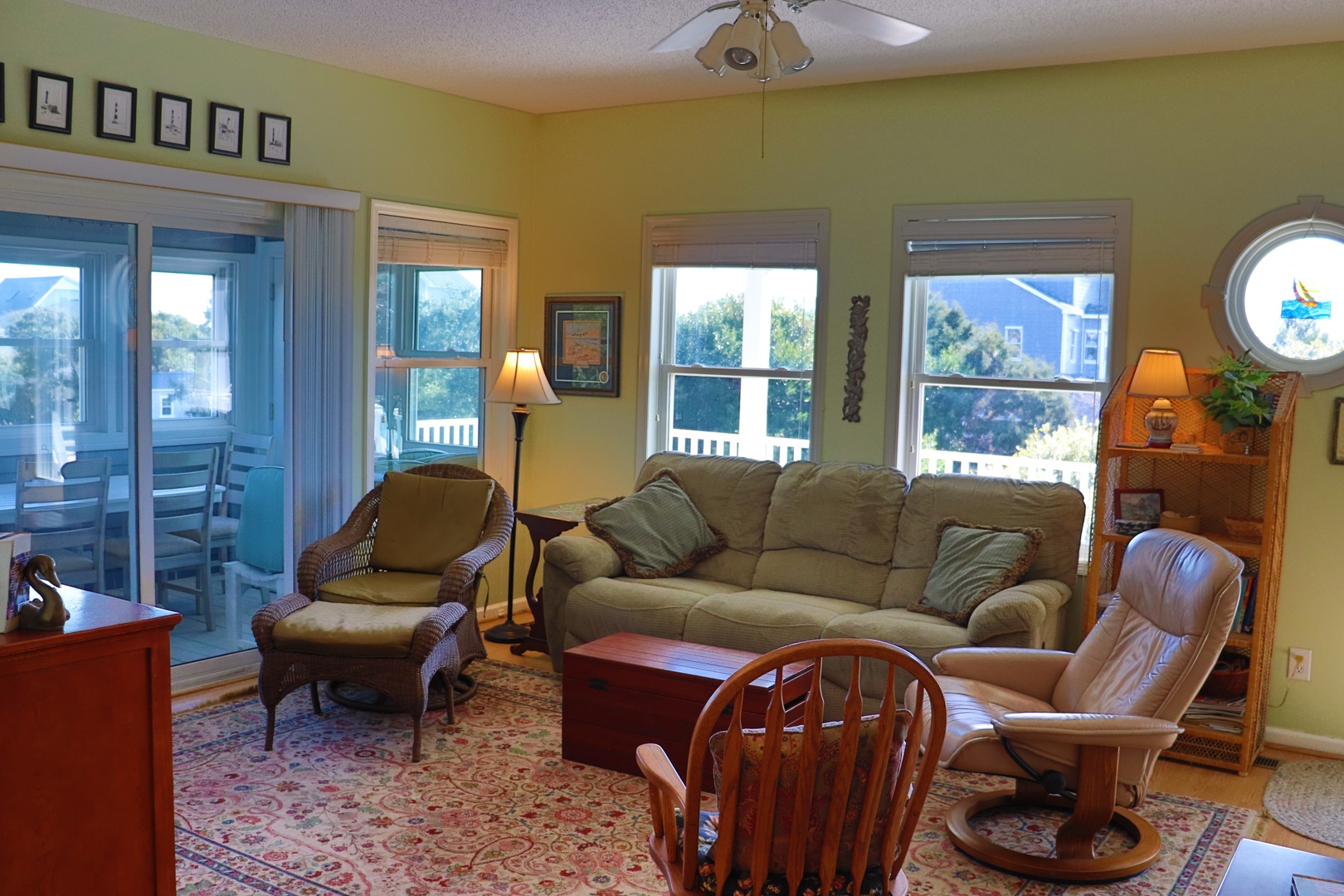 Unwind in your spacious living room with comfortable seating, warm lighting, and peaceful views through multiple windows.