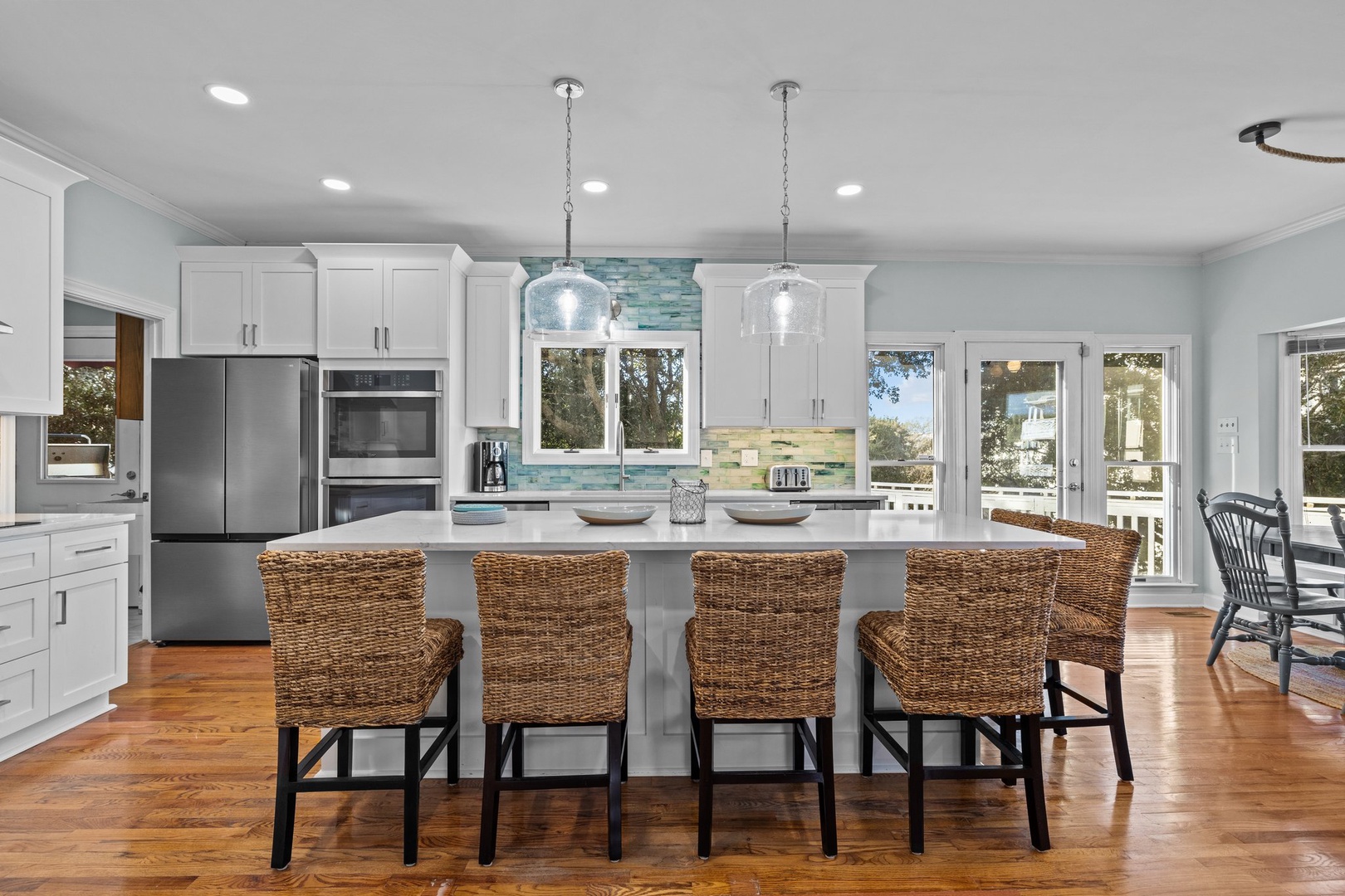 Your dream kitchen awaits with gleaming white cabinets, spacious island, and warm wood floors perfect for cooking memorable meals together.