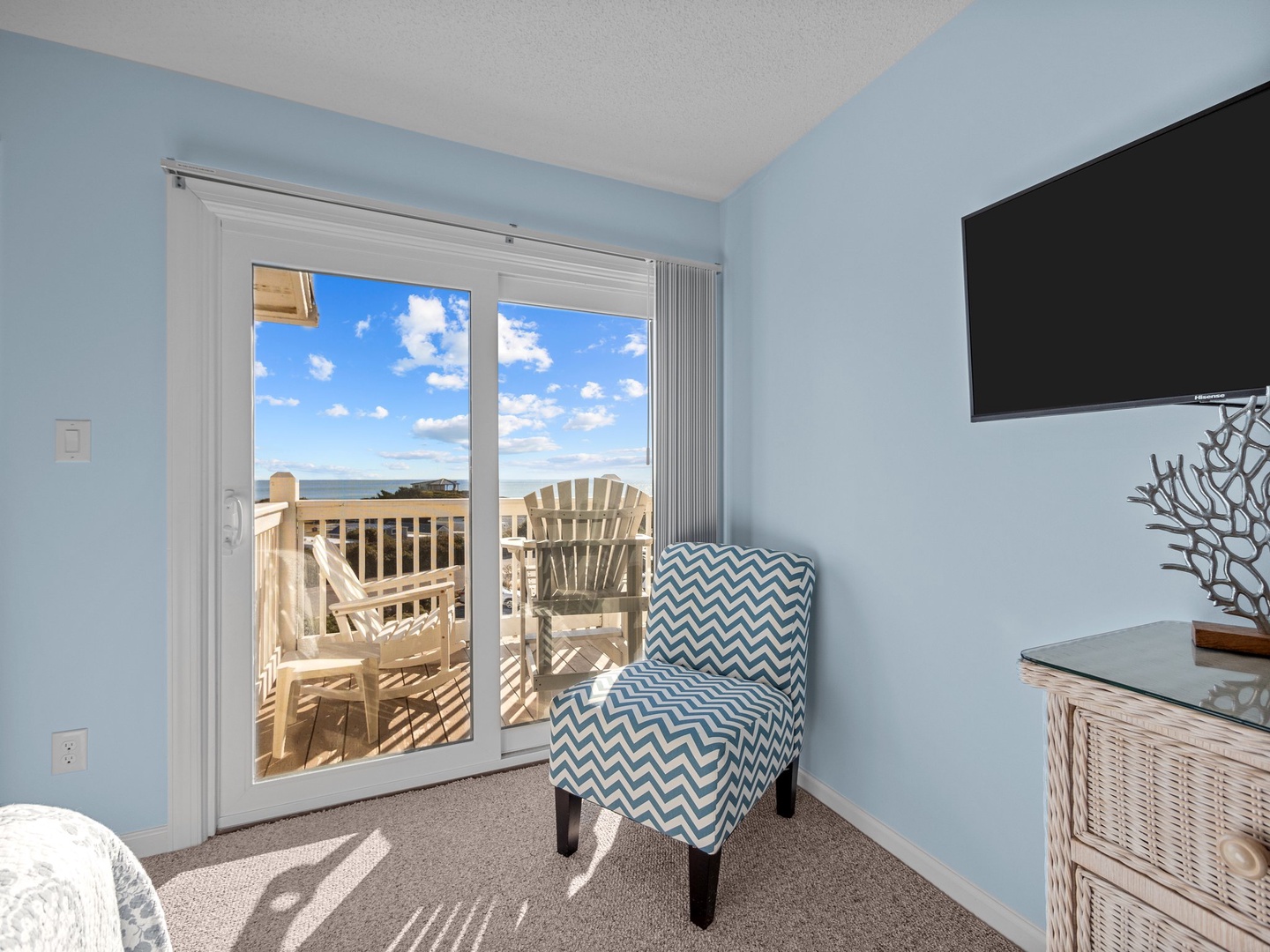 Relax in your cozy chair while enjoying stunning sea views through sliding doors to your private balcony.