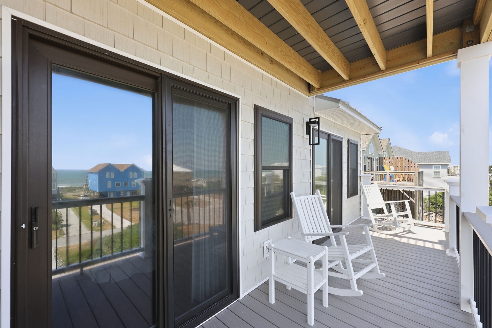 Relax on your private balcony with white Adirondack chairs overlooking the beach and sparkling ocean. The covered outdoor space invites peaceful mornings and sunset evenings just steps from the shore.