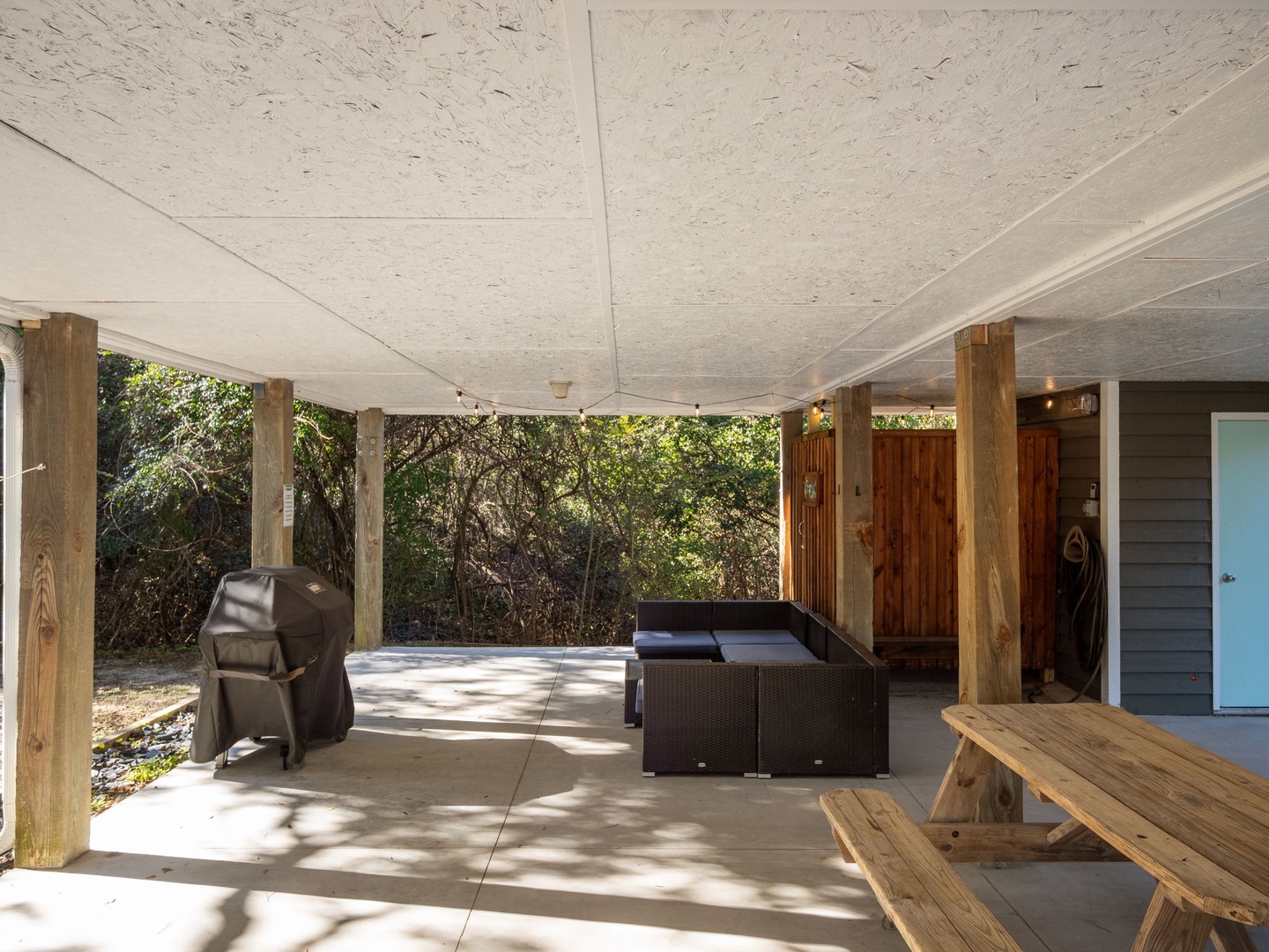 Your covered patio offers the perfect outdoor retreat with comfortable seating, a BBQ grill, and peaceful wooded views for relaxing gatherings.