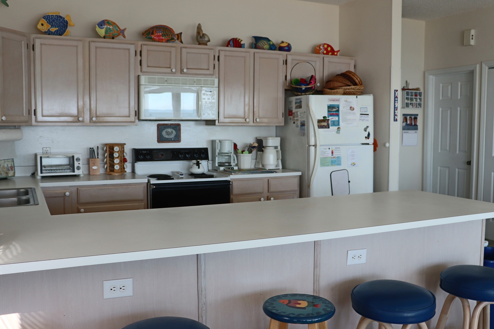 Your fully equipped kitchen features everything you need with ample counter space, colorful decor, and a breakfast bar for morning coffee.