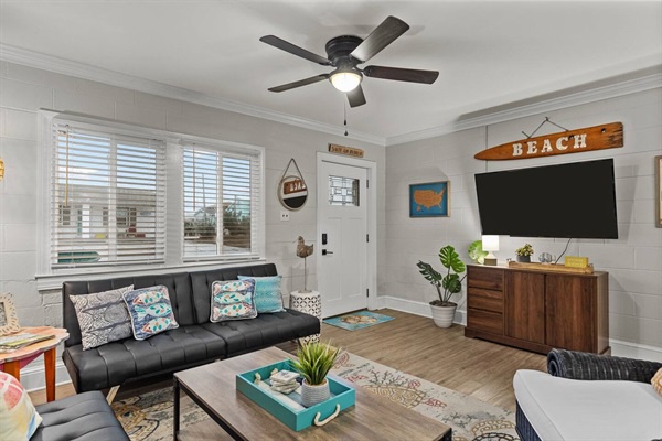 Relax in your spacious living room with coastal decor, comfortable seating, and modern amenities for your perfect beach getaway.