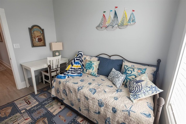 Your coastal sanctuary awaits with a nautical daybed, perfect for afternoon naps or curling up with a book while ocean breezes drift through.