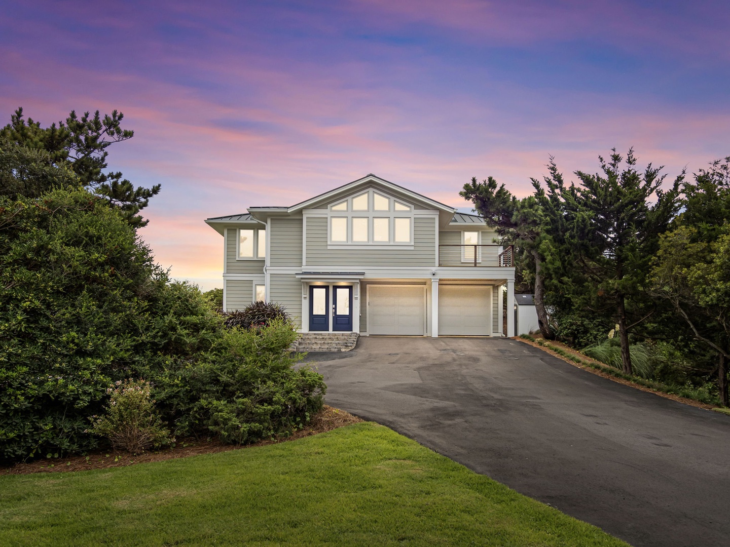 This elegant coastal retreat sits beautifully among mature trees with a stunning twilight sky painting the perfect backdrop for your getaway arrival.