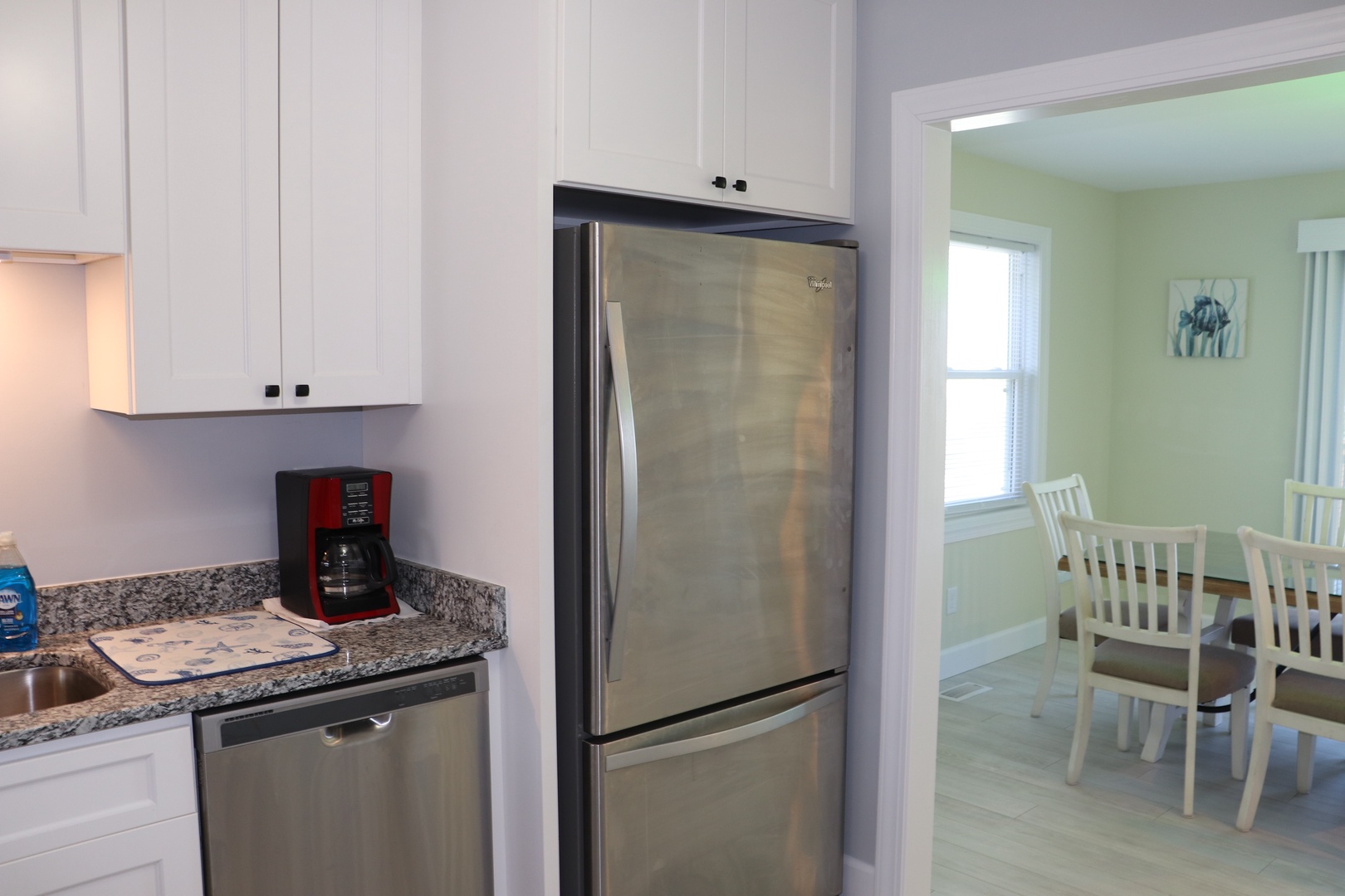 Your modern kitchen awaits with gleaming granite counters, stainless steel appliances, and bright white cabinets perfect for preparing family meals.