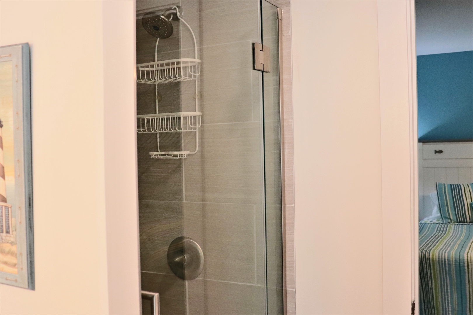Step into your sleek glass-enclosed shower with convenient built-in storage for all your toiletries and modern fixtures.