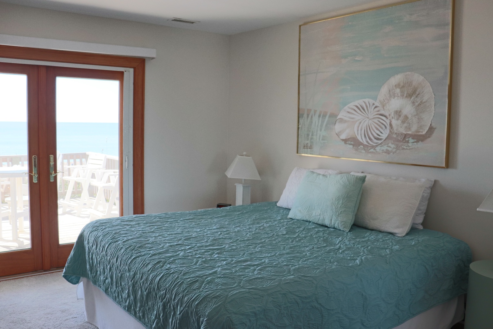 Wake up to ocean views in your serene bedroom, where coastal artwork and soothing sea-glass colors create your perfect beachside retreat.