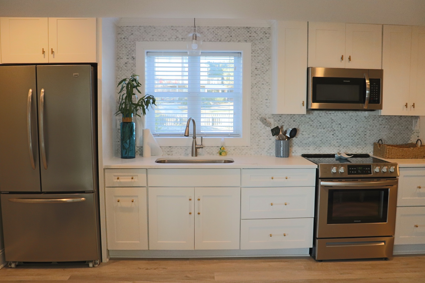 Your modern kitchen features sleek white cabinets, stainless steel appliances, and marble tile backsplash for effortless meal prep.