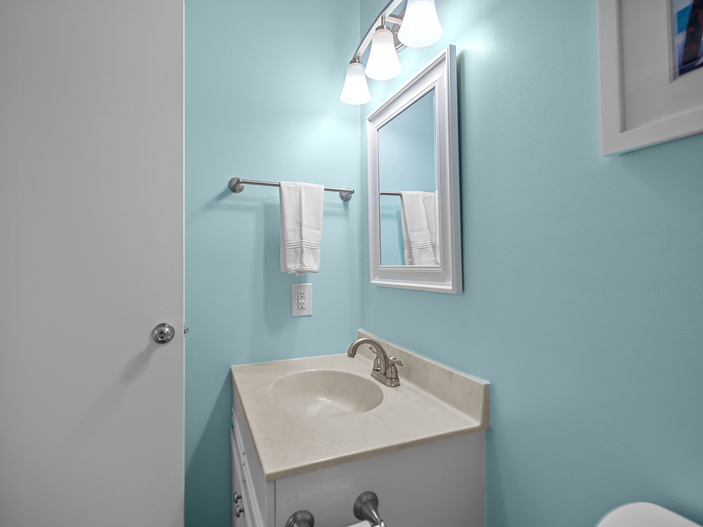 Your private bathroom features calming aqua walls and fresh white towels for a refreshing start to your day.