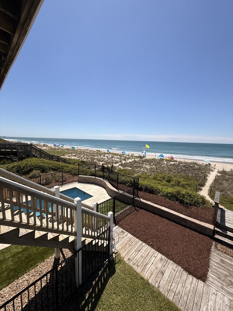 Beachfront property offering direct access to pristine shores, with coastal views framing the arrival and surrounding natural landscape.