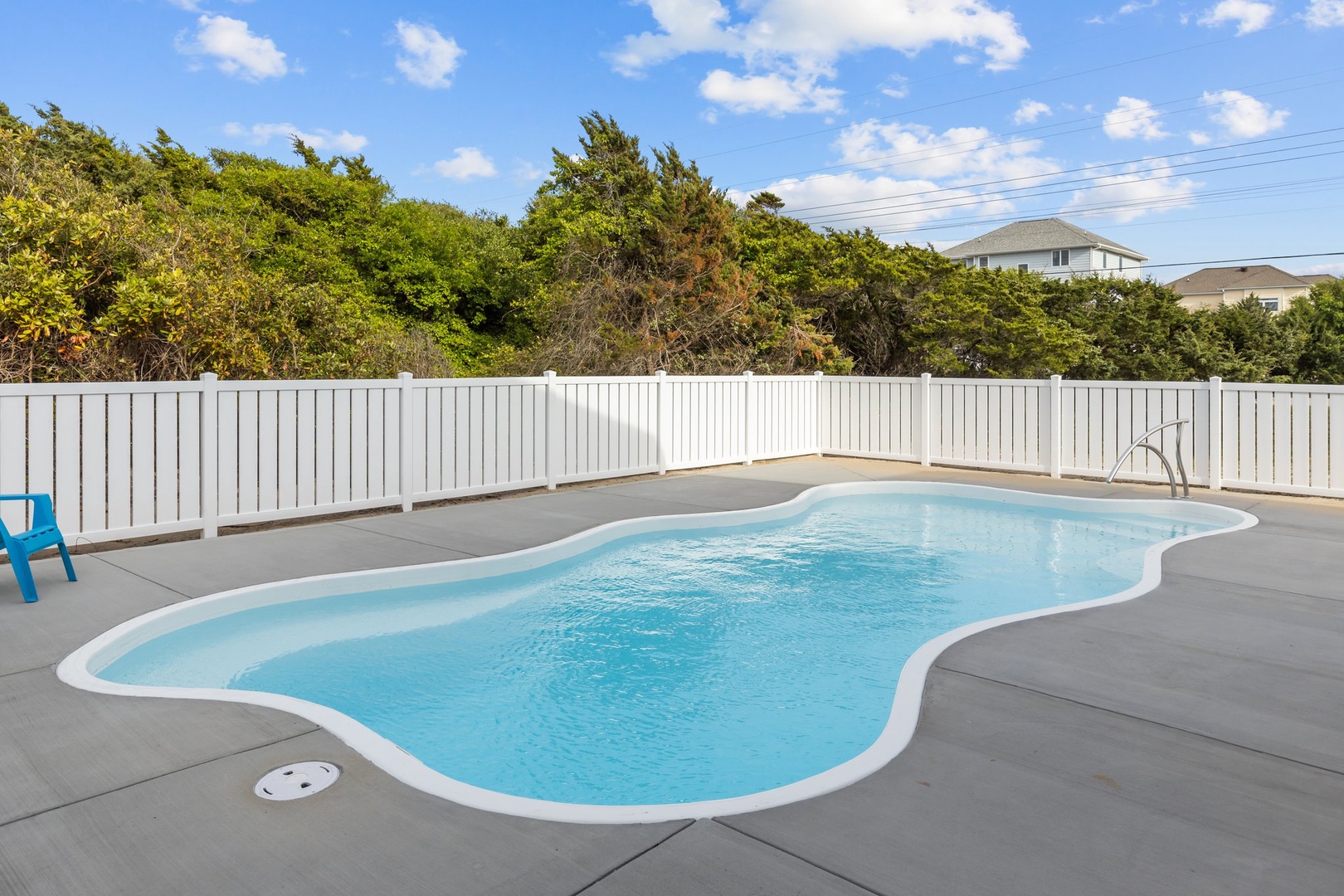 Dive into your private backyard oasis where crystal-clear waters await beneath endless blue skies.