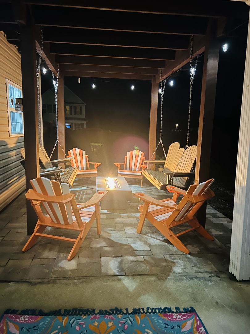 Gather around your private fire pit under twinkling lights, where cozy Adirondack chairs and gentle porch swings create the perfect evening retreat.