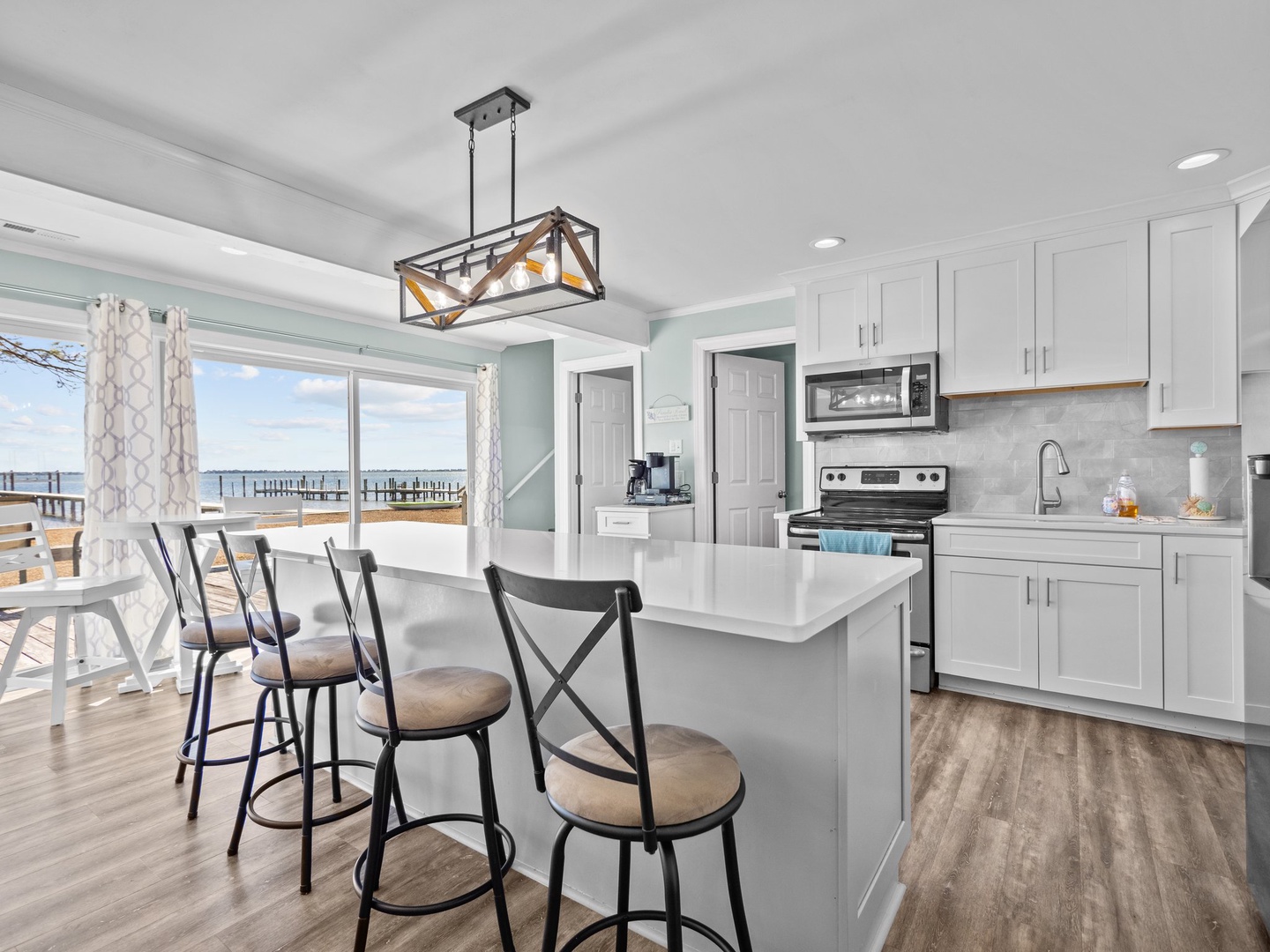 Your fully equipped kitchen flows seamlessly to the waterfront deck, perfect for morning coffee while watching boats drift by.