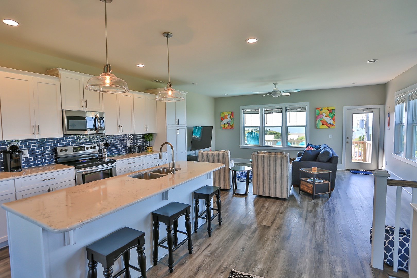 Relax in your bright, open-concept living space featuring a fully equipped kitchen with modern appliances and comfortable seating area.