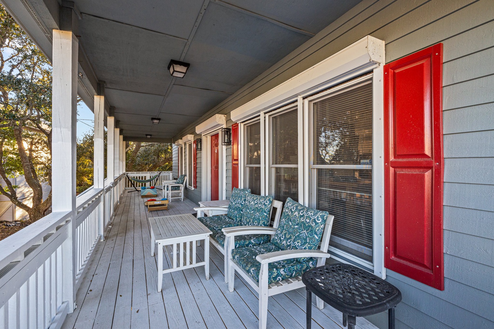 Settle into your private porch with comfortable seating and charming red shutters, perfect for morning coffee or evening relaxation.