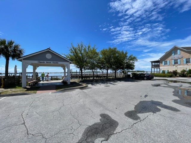 Waterfront property with covered gazebo and dock access beneath clear blue skies.