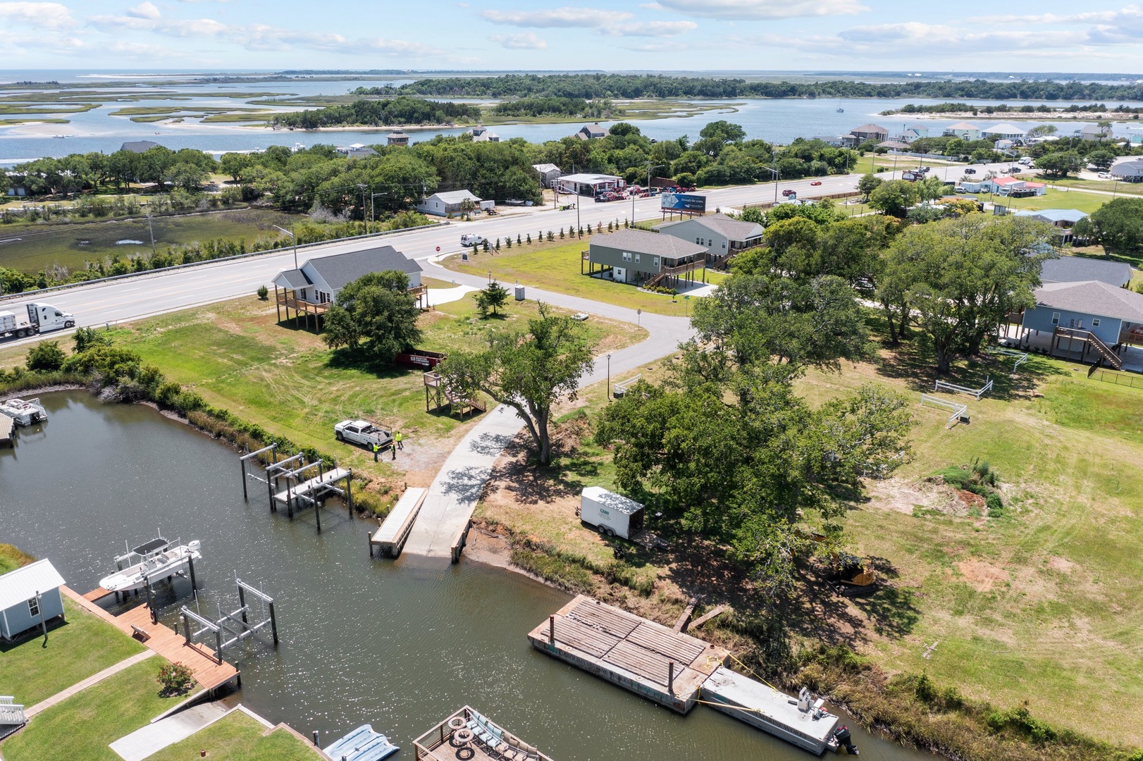 Aerial view of waterfront community featuring canal access, boat docks, and recreational vehicle areas surrounded by natural landscapes.