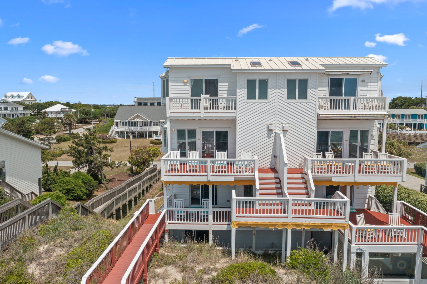 This multi-level beachfront property features tiered decks, a private boardwalk to the shore, and coastal views from a quiet residential neighborhood. The home offers distinct outdoor spaces for relaxation and direct beach access.