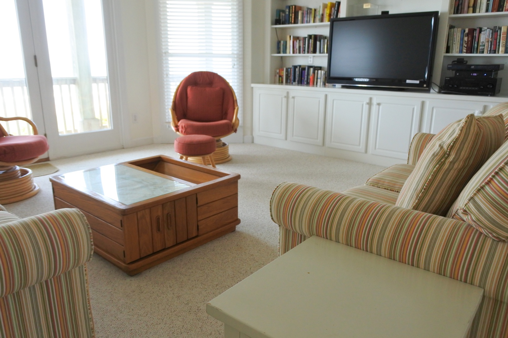 Settle into your comfortable striped armchairs with a good book from the built-in library, perfect for quiet evenings.