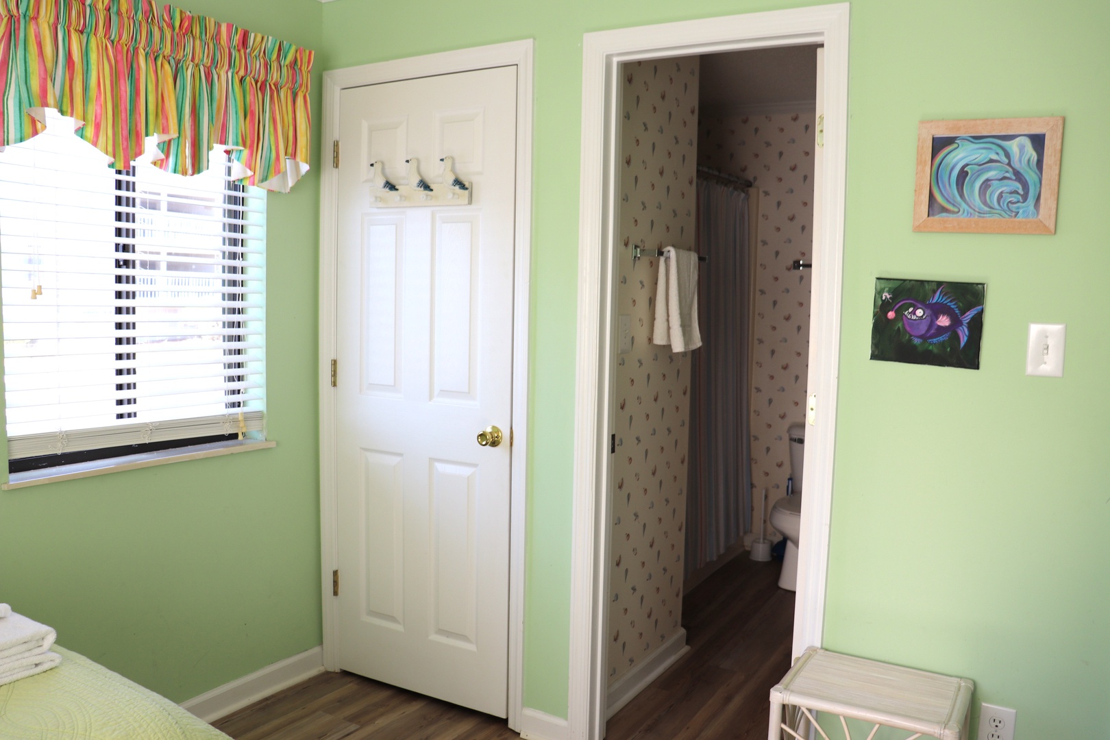 Step into your cheerful green bedroom where playful artwork and colorful curtains create a welcoming space for relaxation.