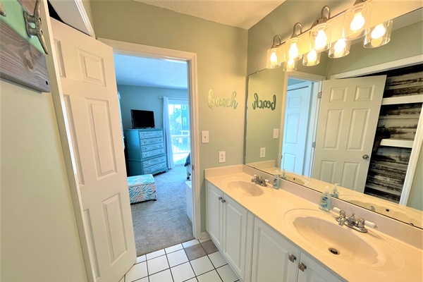 Your private bathroom features dual sinks and bright vanity lighting, perfect for getting ready together in the morning.