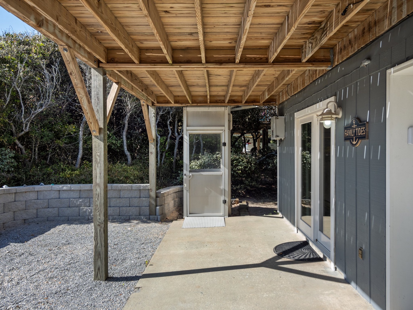 Modern entrance featuring a covered wooden pergola and stylish blue and white exterior design.