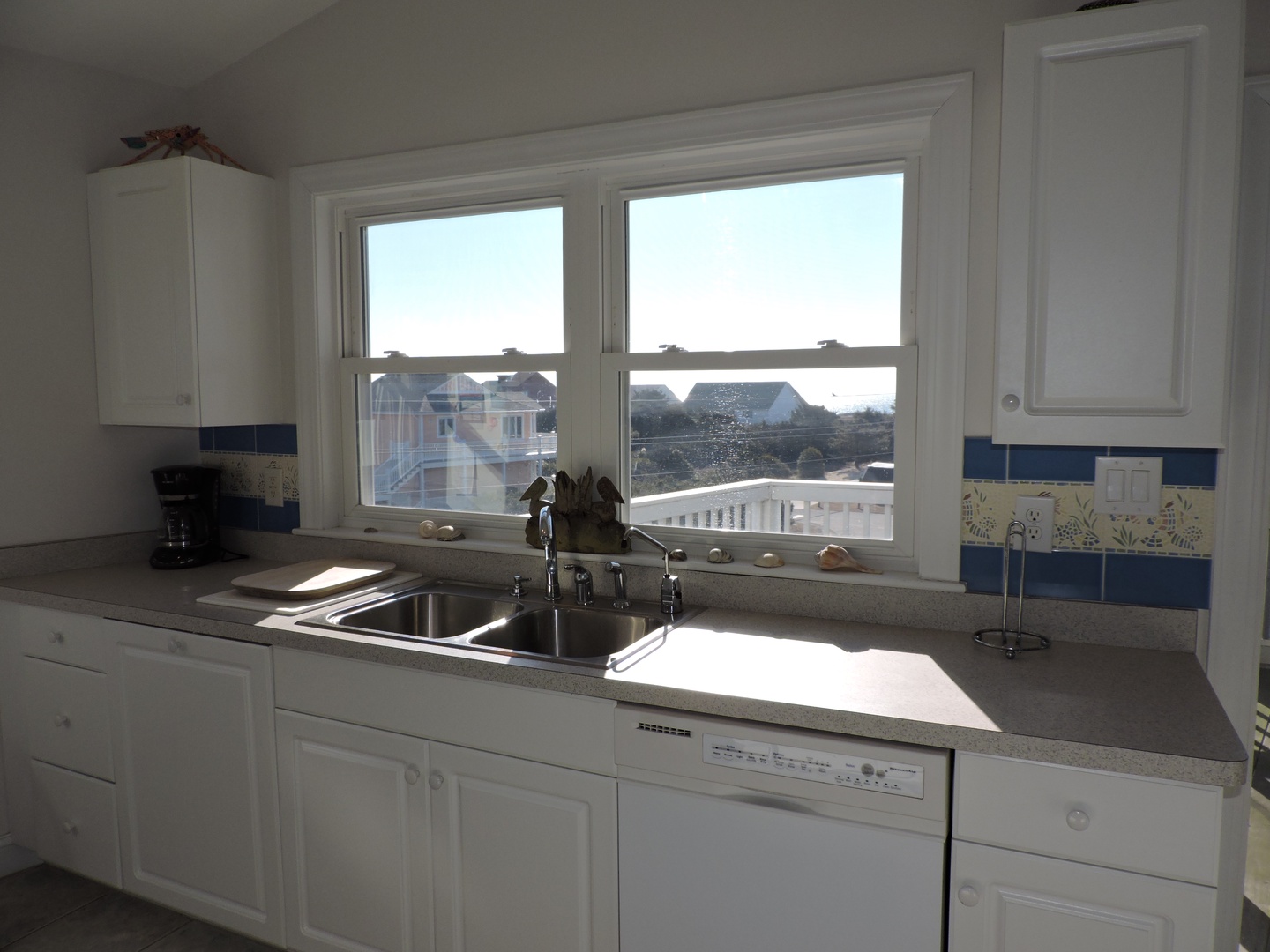 Your kitchen window frames coastal views while you cook, with sunny counters perfect for morning coffee prep.
