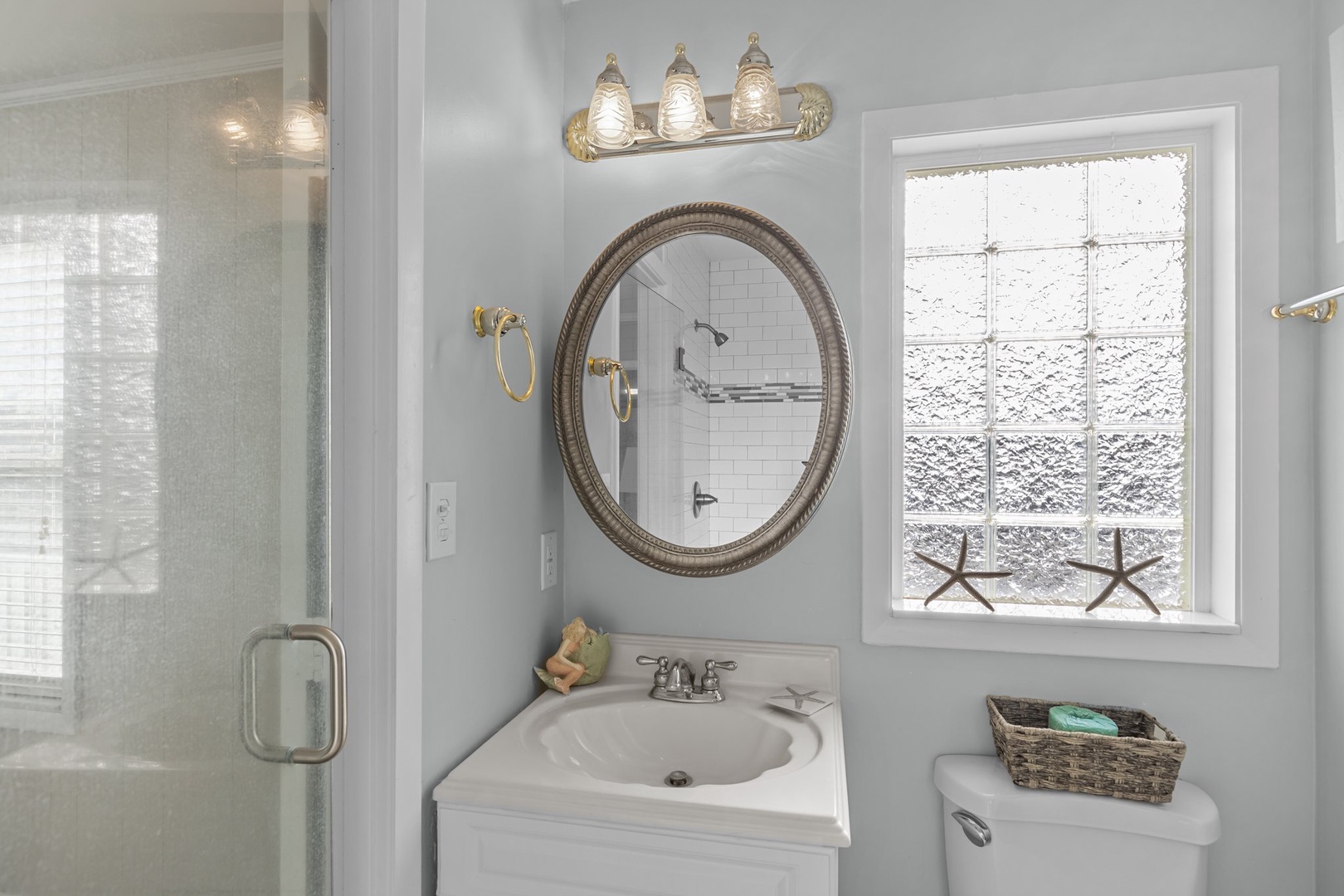 Step into your pristine bathroom sanctuary with coastal charm - soft lighting, elegant fixtures, and thoughtful touches create your perfect retreat.