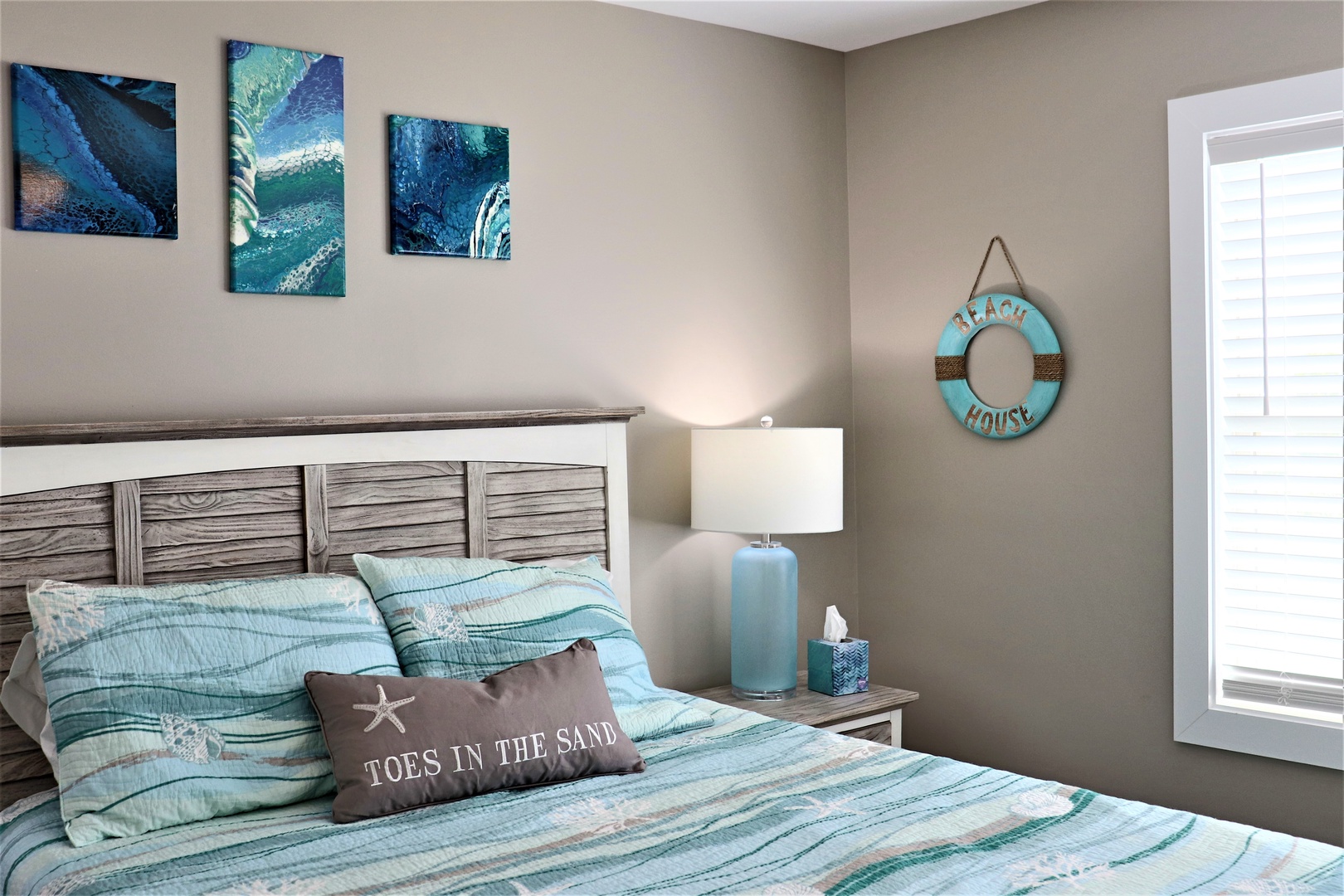 Drift off in your coastal-themed bedroom where ocean blues meet weathered wood, creating the perfect beach house vibe for your getaway.
