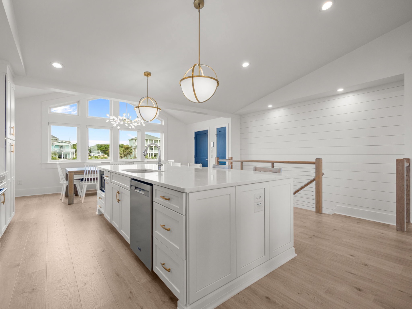 This bright, modern kitchen features elegant pendant lighting and a spacious island where you'll love preparing meals while enjoying coastal views.