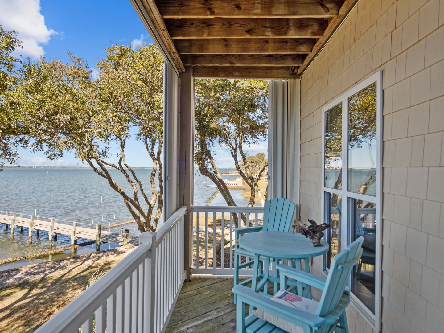 Relax on your private waterfront balcony with turquoise chairs and stunning lake views, where gentle breezes and peaceful moments await.