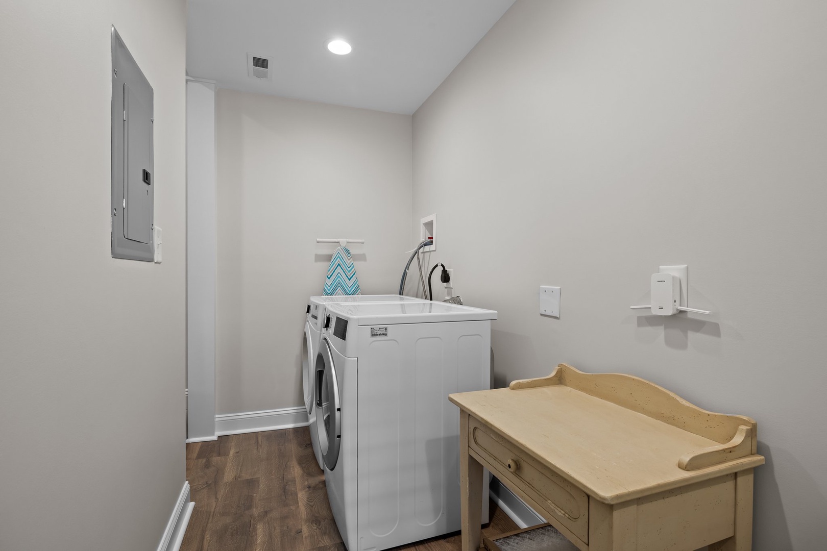 Keep your wardrobe fresh in this dedicated laundry room featuring modern washer and dryer, convenient sink, and ample folding space for your comfort.