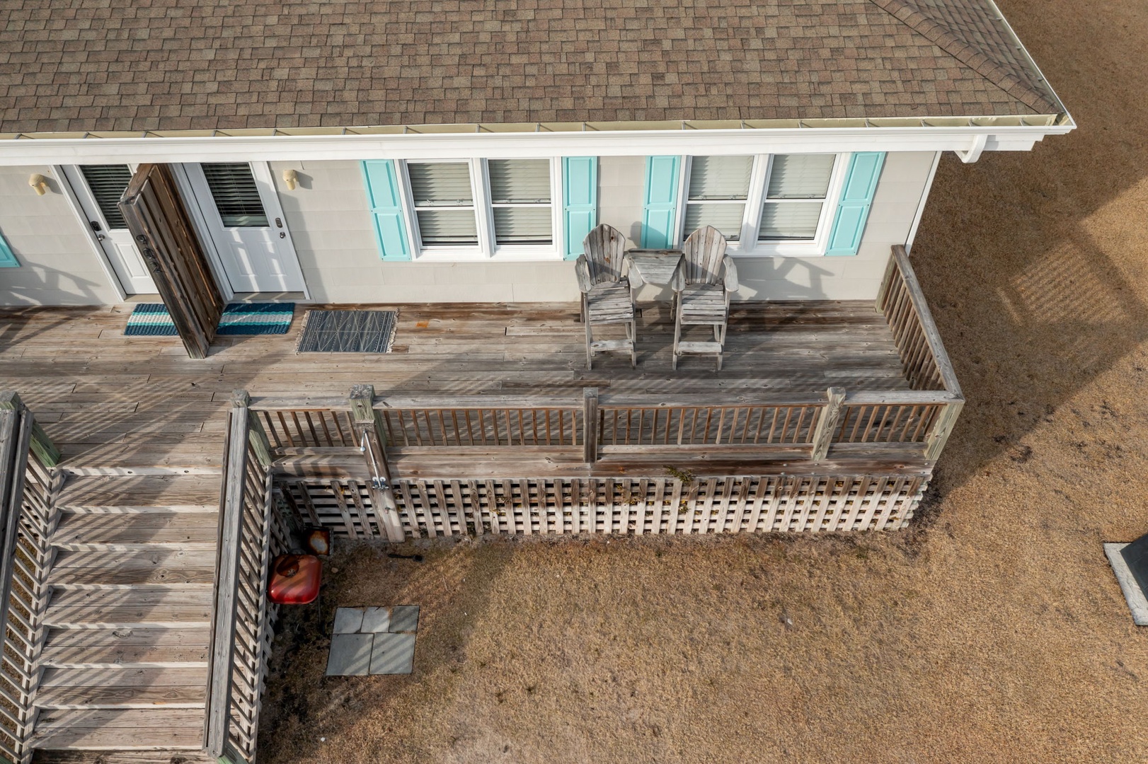 Charming coastal cottage with wraparound deck featuring comfortable seating and beach access.