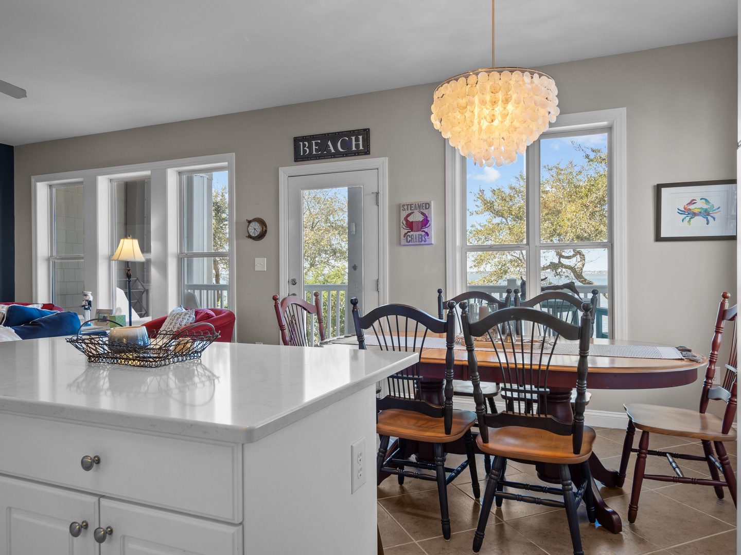 Gather around your bright kitchen island while the elegant chandelier casts warm light over shared meals and conversations.