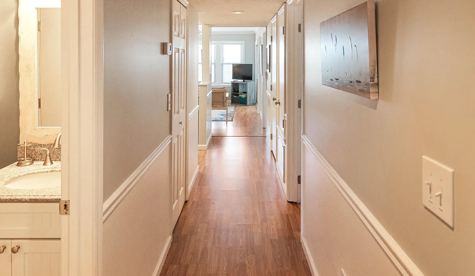 Walk through your bright hallway with gleaming hardwood floors, leading to comfortable living spaces and modern amenities throughout.