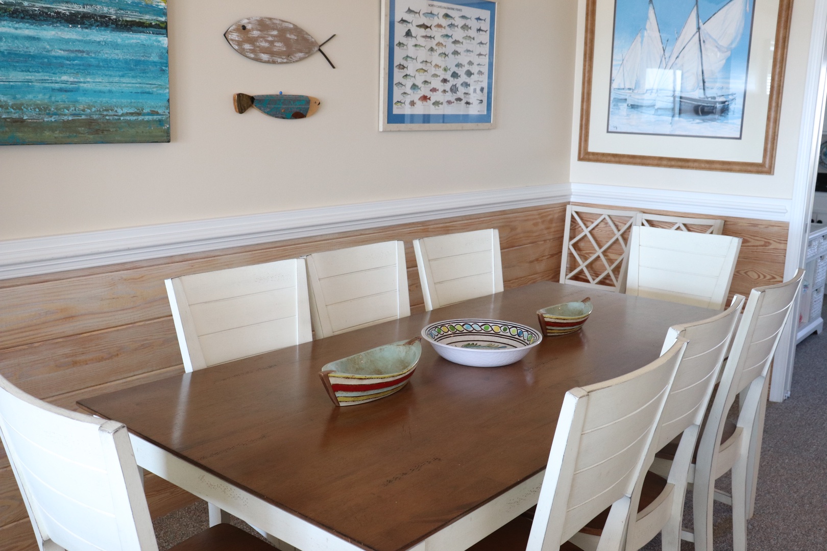 Gather around your spacious dining table surrounded by coastal art and nautical charm, perfect for memorable family meals.