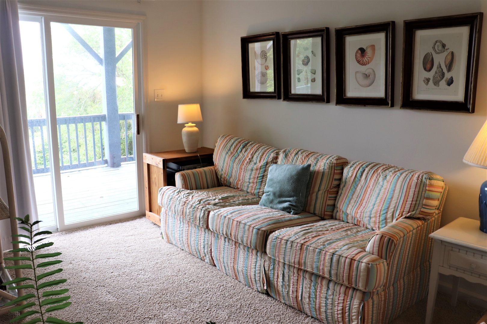 Sink into this cozy striped sofa while natural light filters through your private balcony doors, creating the perfect spot for relaxation.
