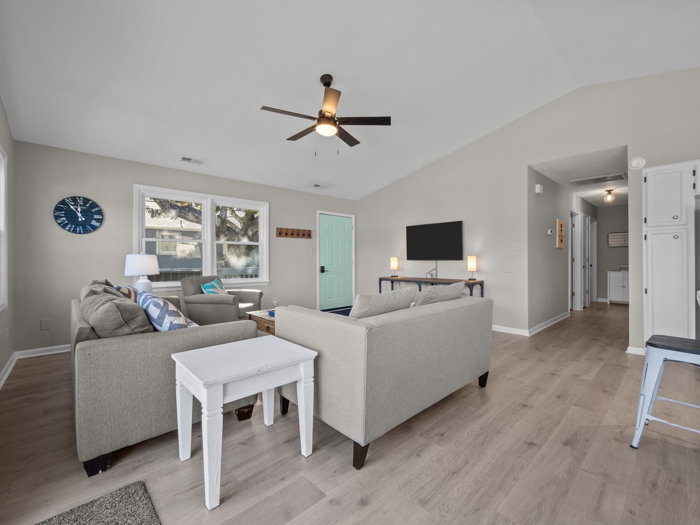 Sink into plush gray sofas in your bright, modern living room with vaulted ceilings and refreshing coastal touches throughout.