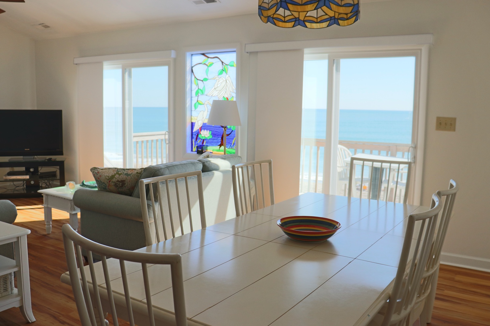 Gather around this spacious dining table with stunning sea views through your private balcony doors, perfect for memorable meals.