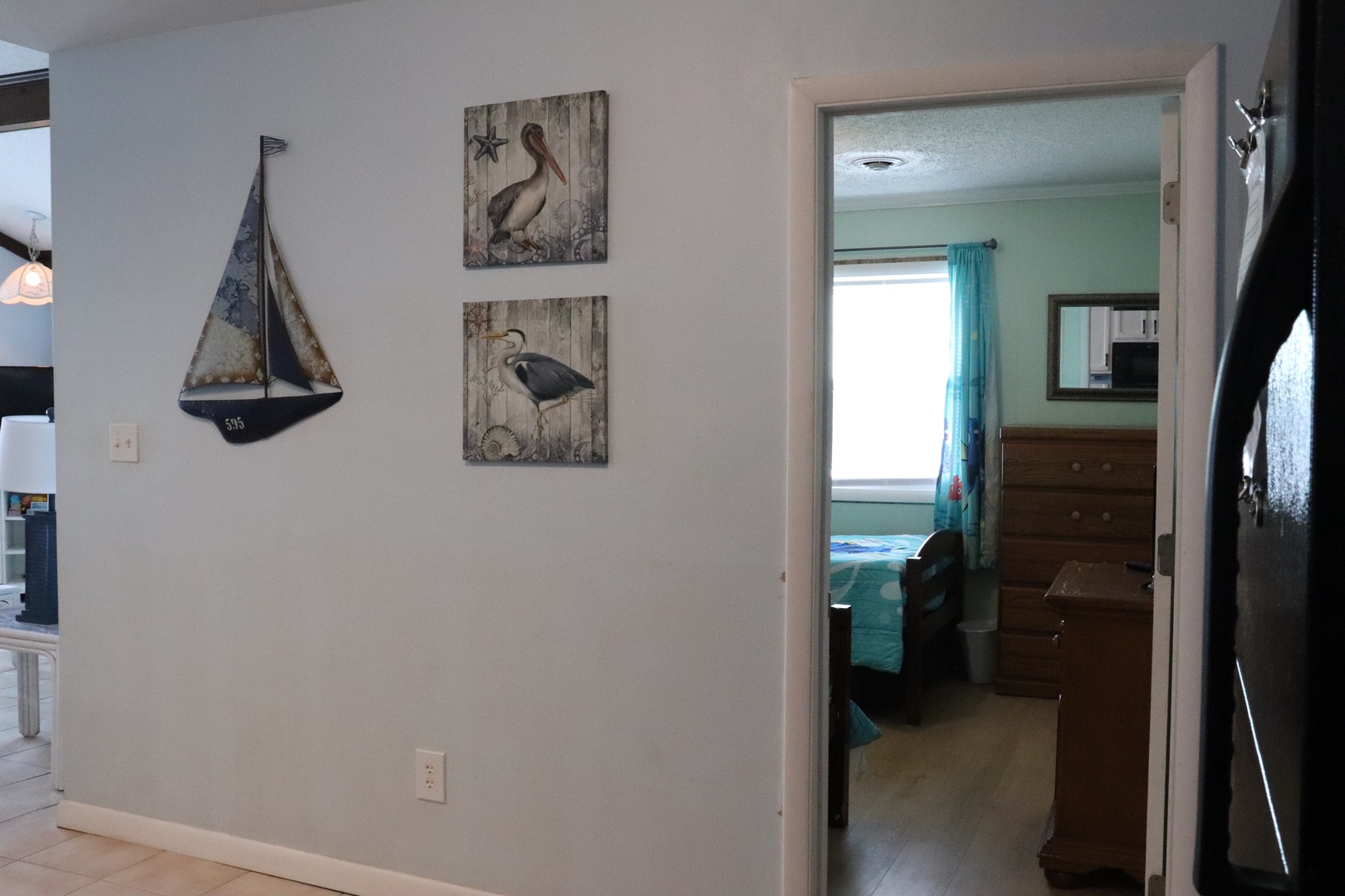 Coastal charm meets comfort. Nautical accents guide you to your restful bedroom, where soothing turquoise tones and warm wood create your serene seaside retreat.