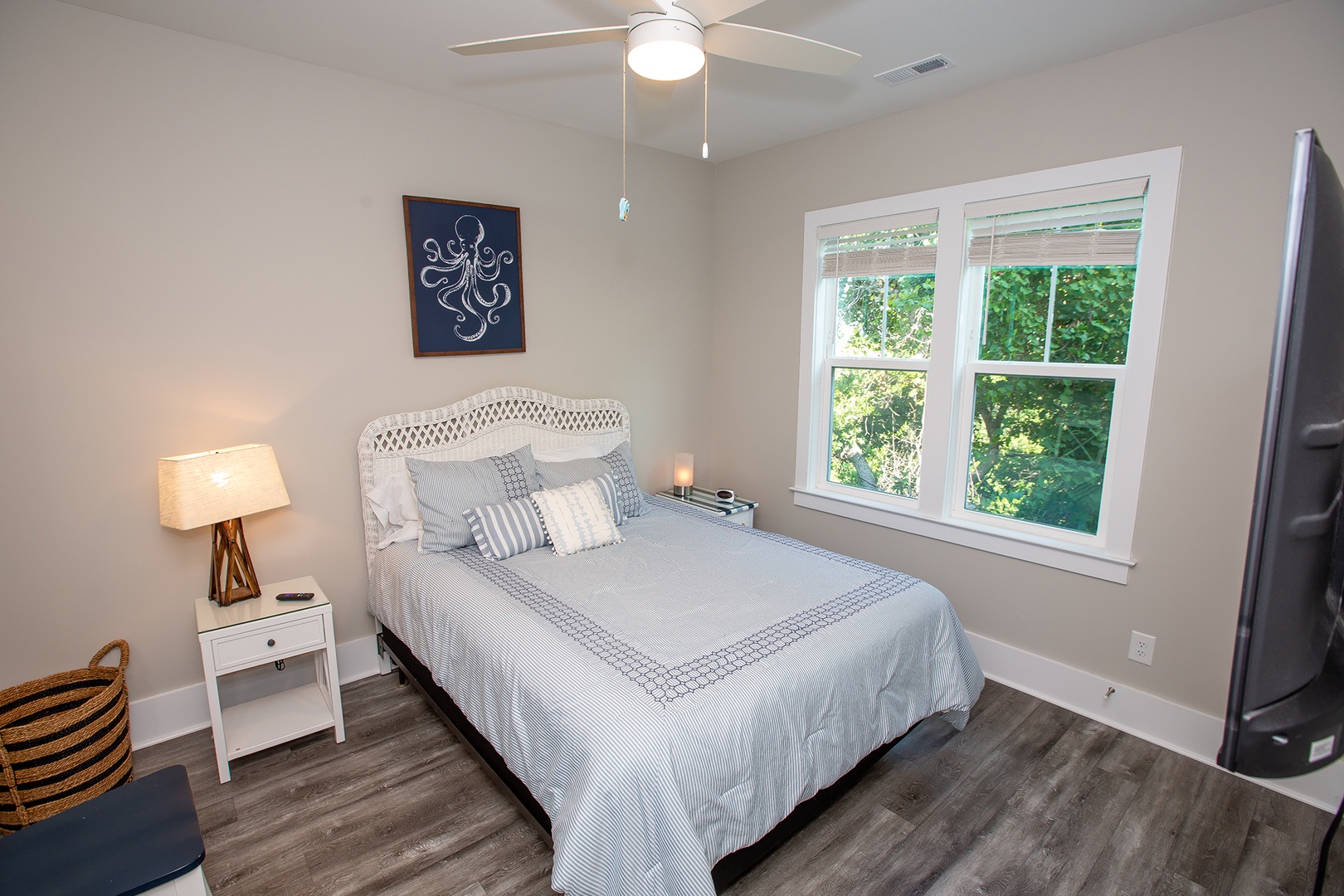 Sink into the plush blue bedding and feel the gentle breeze from your ceiling fan as you gaze at leafy garden views through the bright windows.