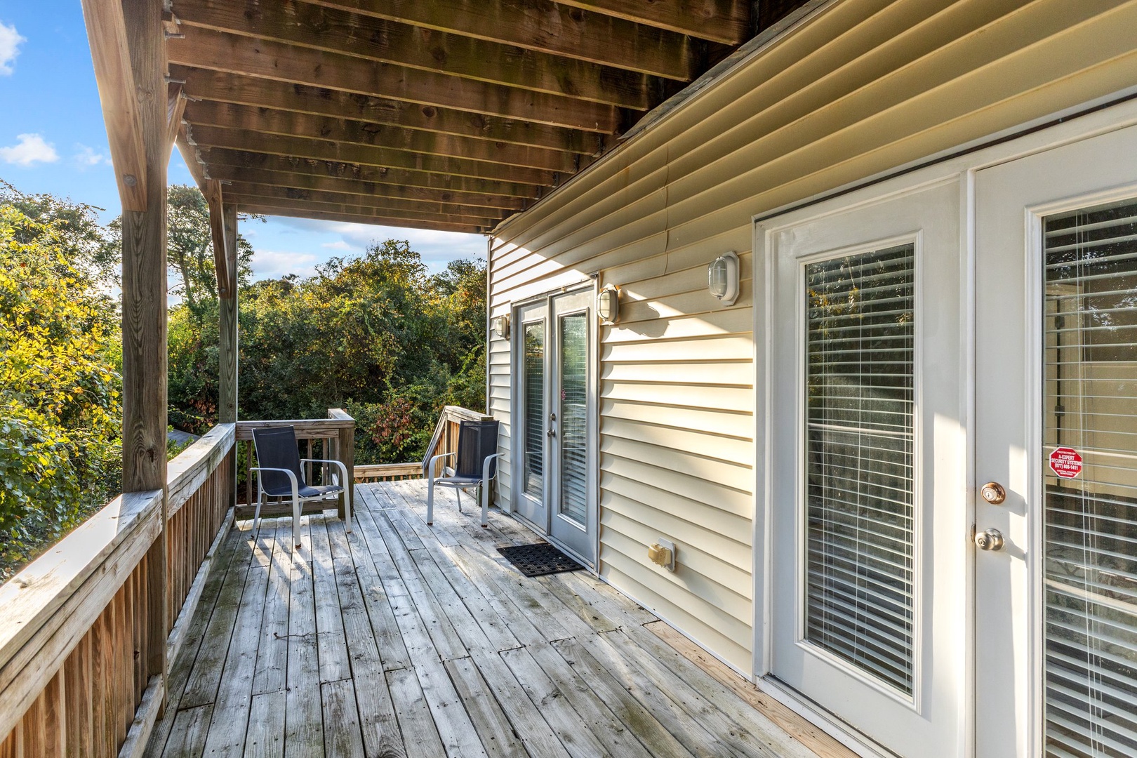 Step onto your private deck where morning coffee meets forest views, with cozy seating under the covered overhang.