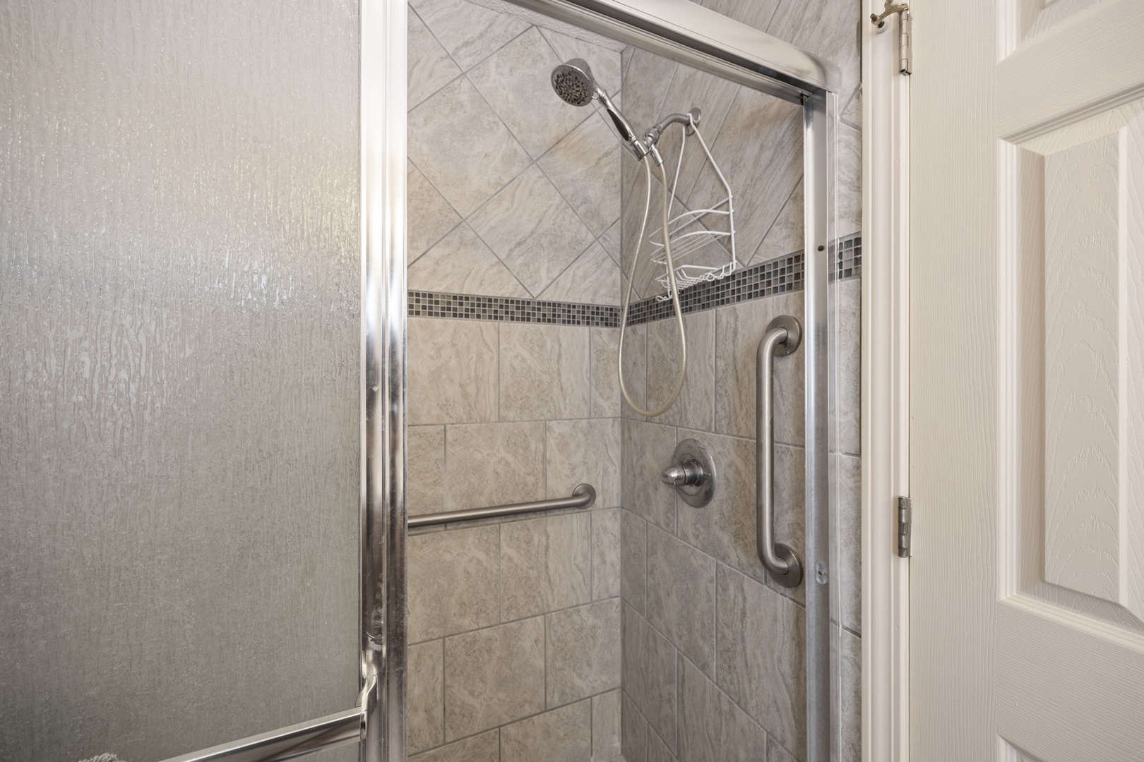 Step into your spacious walk-in shower featuring elegant marble tiles and a refreshing rain showerhead for the ultimate relaxation experience.