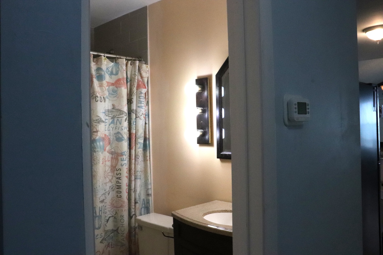 Step into your private bathroom with soft lighting and coastal charm—a nautical-themed shower curtain and modern fixtures create a cozy retreat after your adventures.