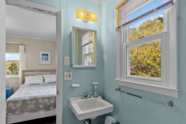 Your tranquil bathroom sanctuary features soft blue walls and natural light streaming through windows, creating a peaceful start to your day.