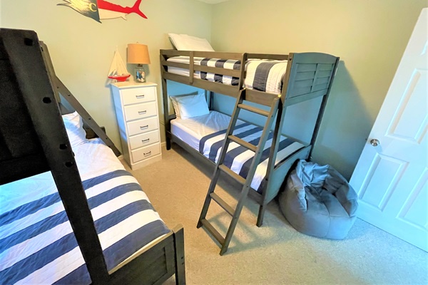 Your kids will love this fun bunk bed room with airplane decor and cozy blue striped bedding for perfect sleep after adventure-filled days.
