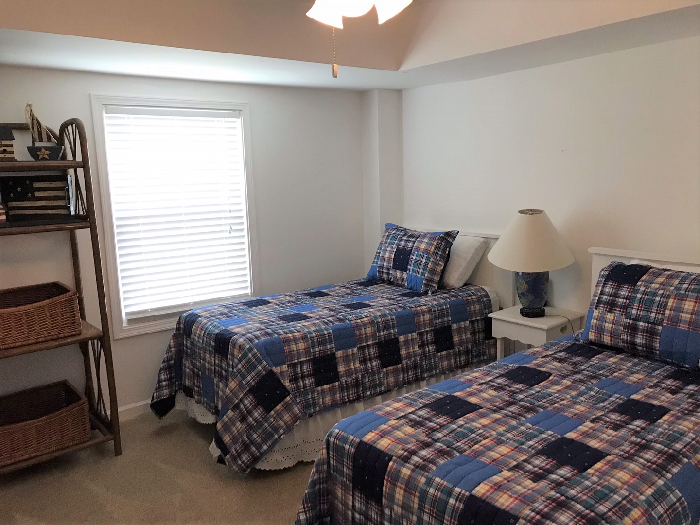 Settle into your cozy twin bedroom with plaid quilts and natural light streaming through. Perfect for restful nights after exploring.